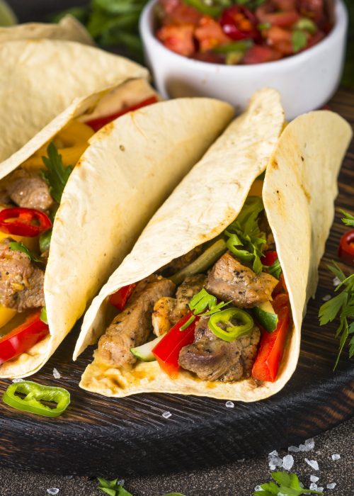 Mexican pork tacos with vegetables and salsa. Traditional Latin american food.